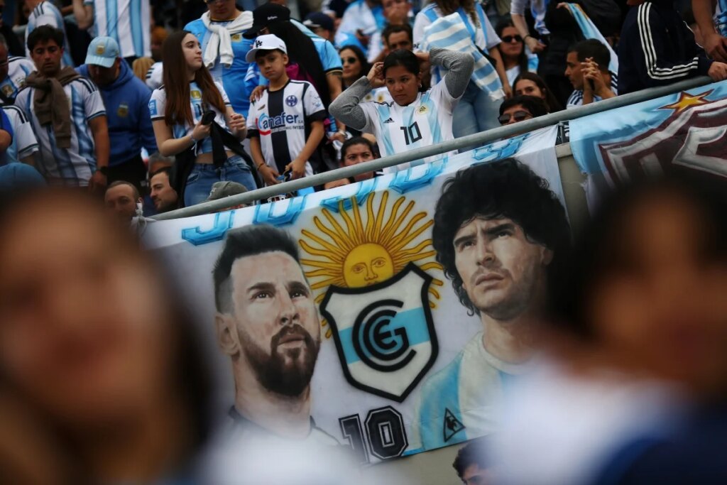 Faixas, máscara e tatuagem: torcida homenageia Messi antes de despedida